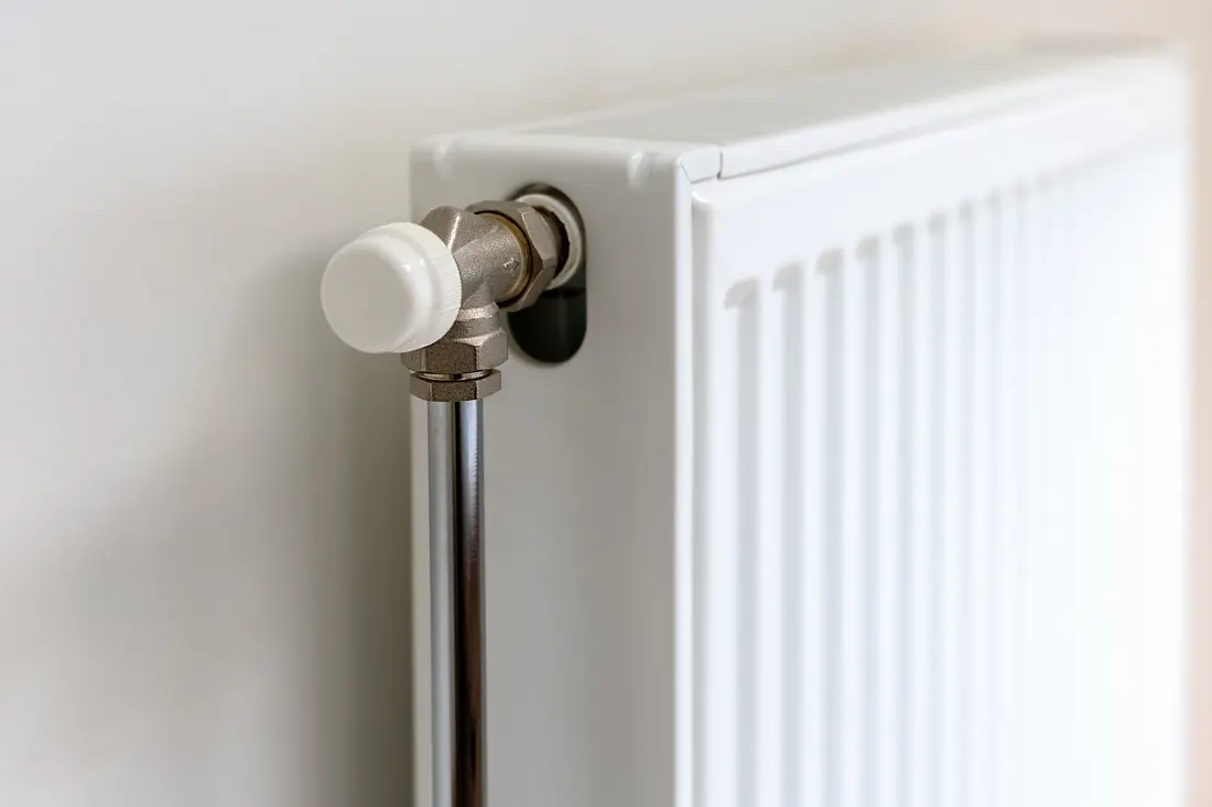 The end of a white panel radiator and the valve feeding it
