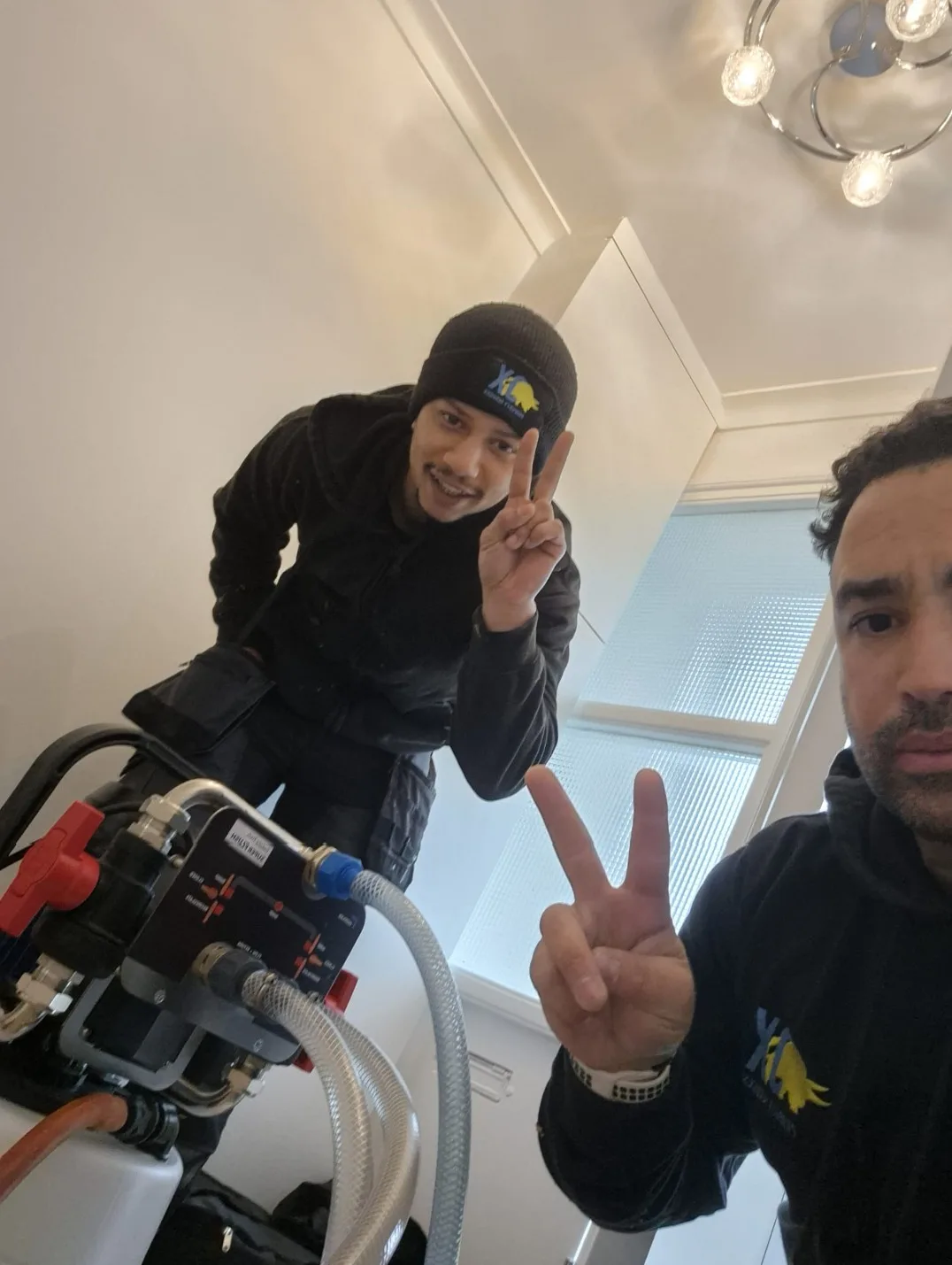 Two OX engineers on site with a power flushing unit during a central heating clean